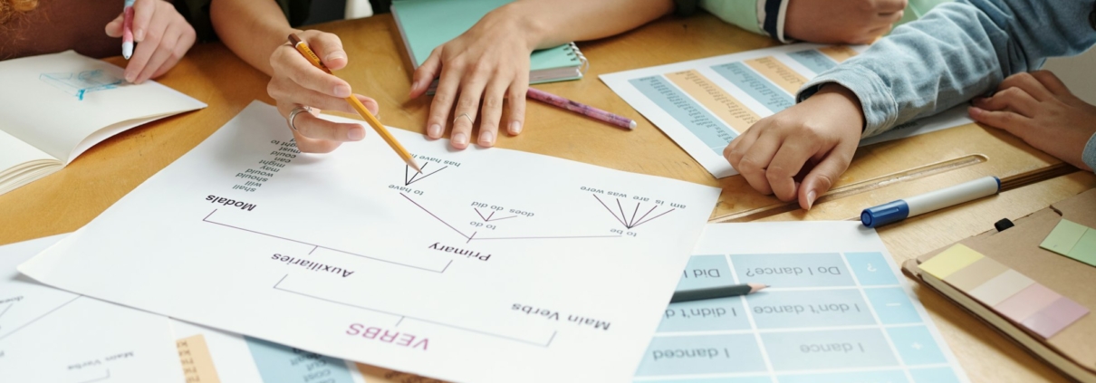 Hands of young teacher with pencil pointing at document with grammar rules