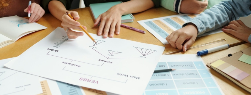 Hands of young teacher with pencil pointing at document with grammar rules