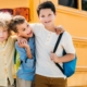 happy little schoolboys embracing in front of school bus