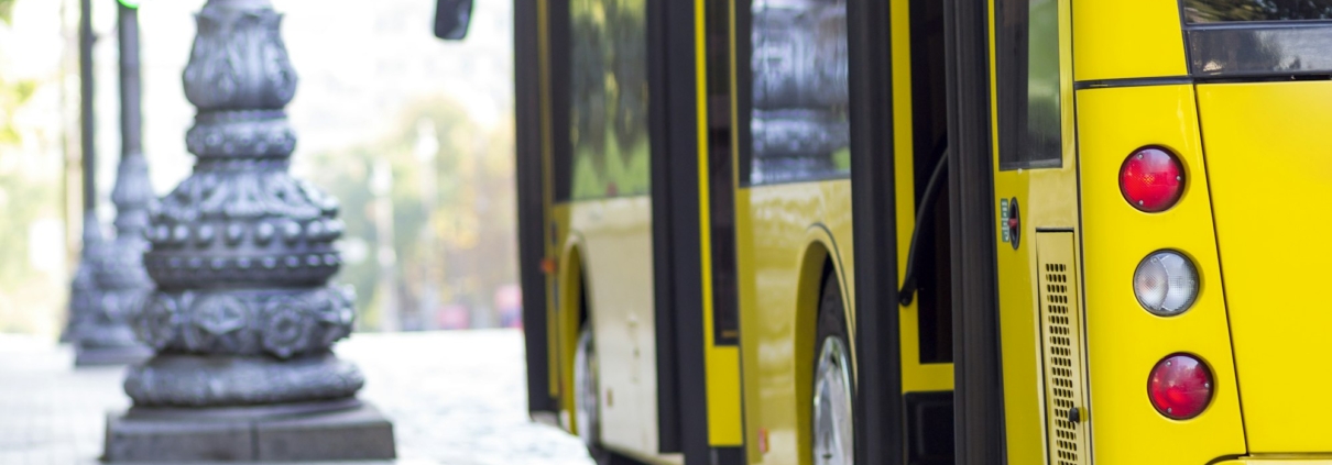 Modern yellow city bus with open doors at bus station