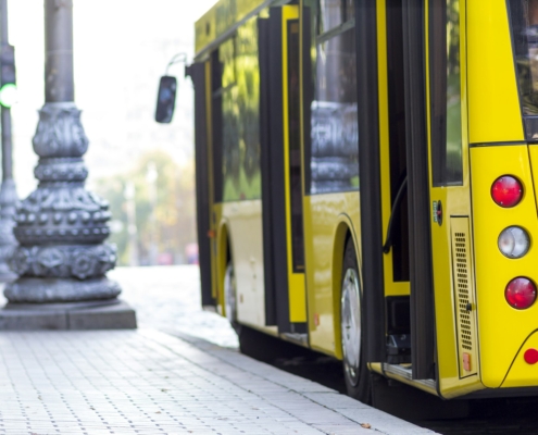 Modern yellow city bus with open doors at bus station