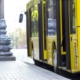 Modern yellow city bus with open doors at bus station