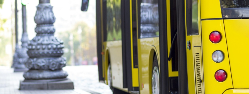 Modern yellow city bus with open doors at bus station