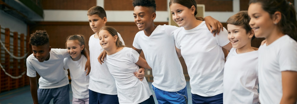 Multi-ethnic group of happy school children having PE class at at school gym.