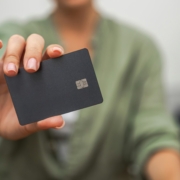 close-up hand dark credit card with chip, contactless payments, mobile banking.