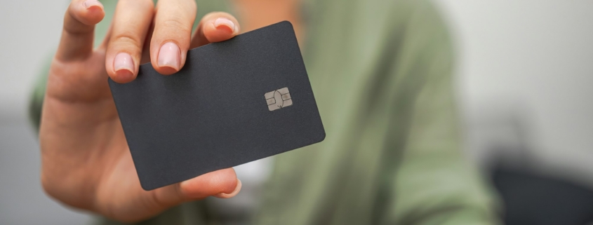 close-up hand dark credit card with chip, contactless payments, mobile banking.